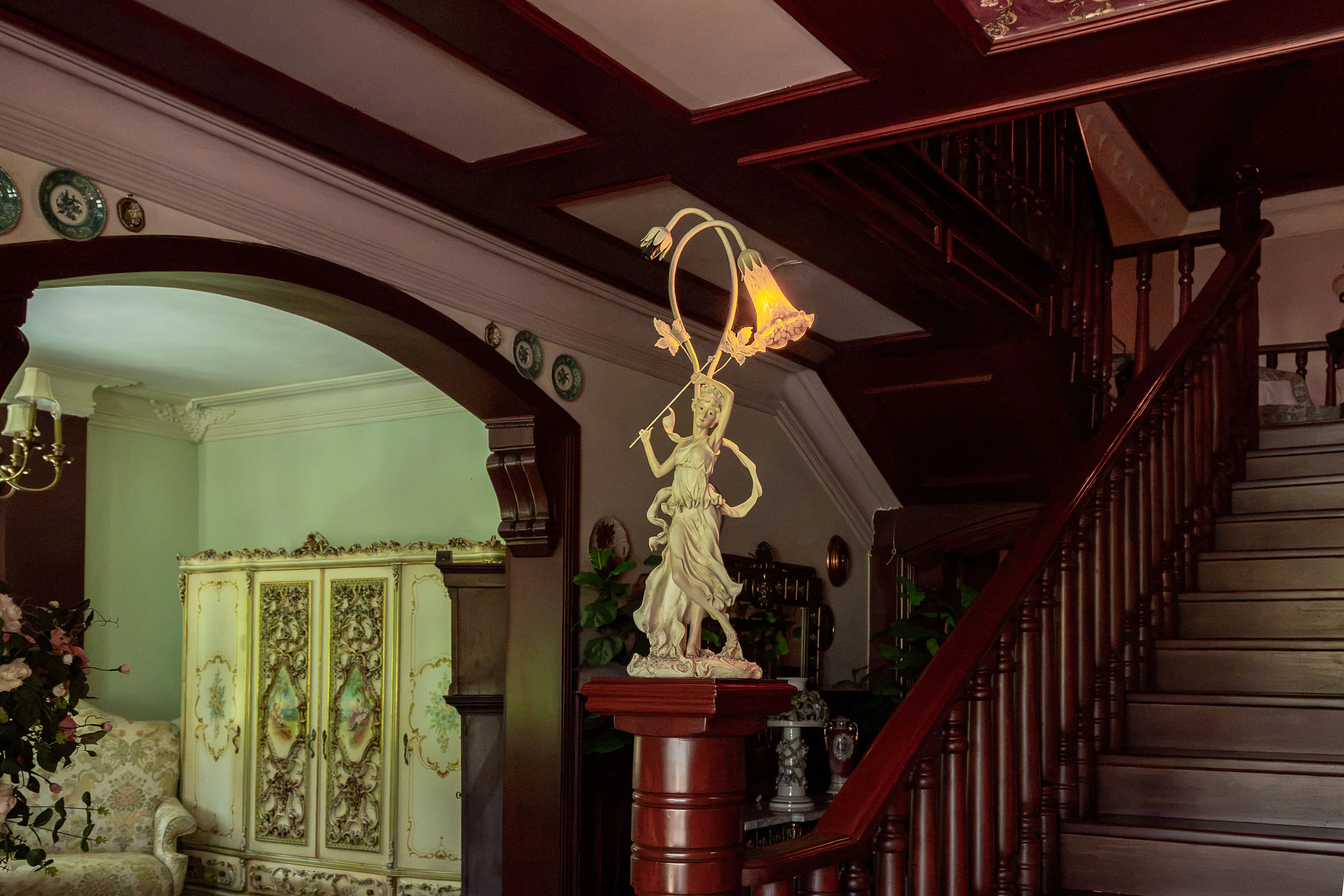 Carved mahogany stair pillar and pedestal near the entry